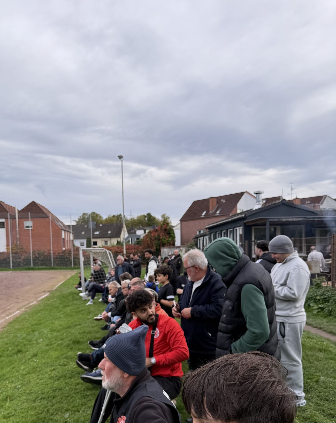 Amacspor-Community am Spielfeldrand bei bewölktem Himmel